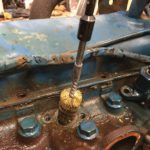 a person is cleaning a rusty engine with a brush