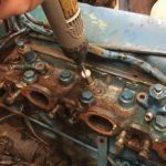 a person is using a drill on a blue engine