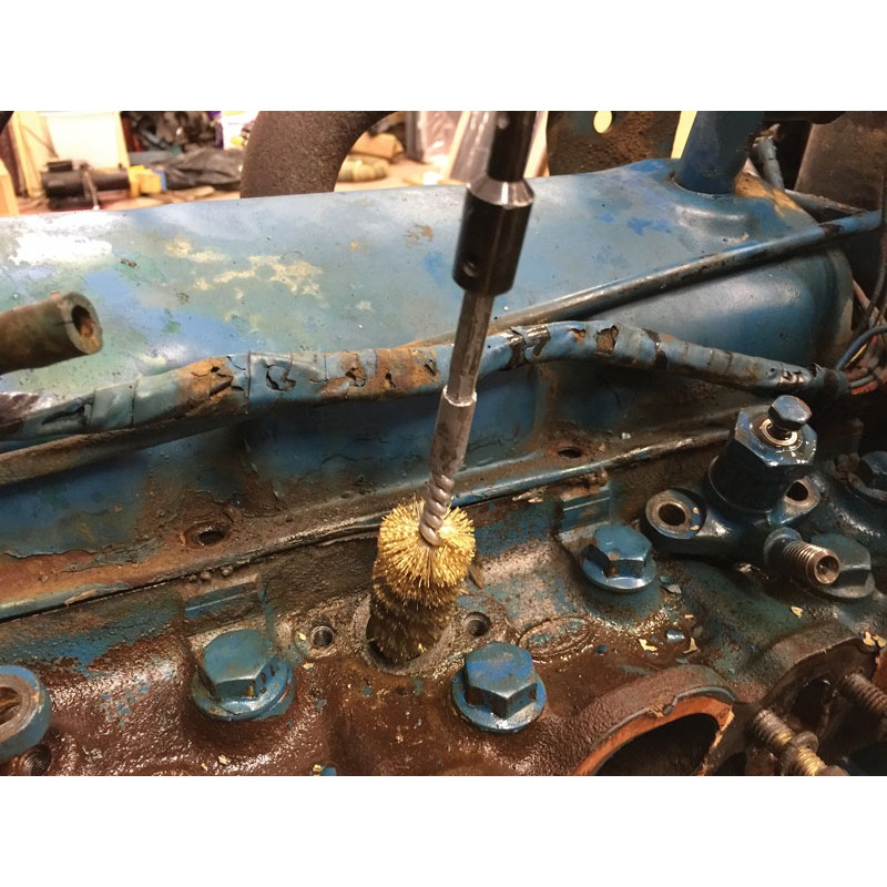 8090b_diesel_injector_seat_cleaning_kit_product_action_3 a person is cleaning a rusty engine with a brush