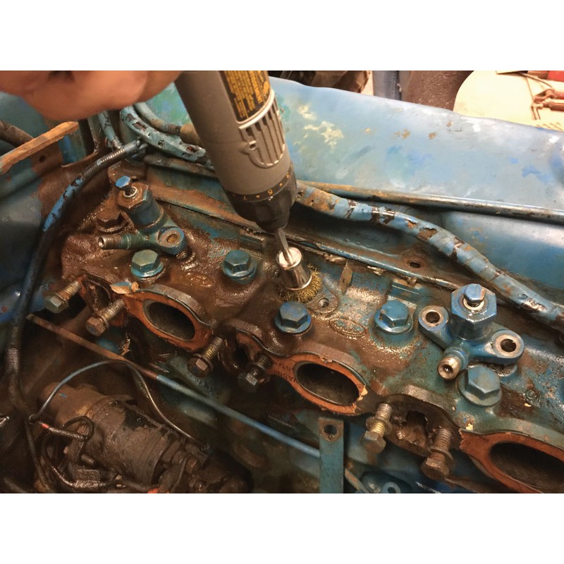8090b_diesel_injector_seat_cleaning_kit_product_action_4 a person is using a drill on a blue engine