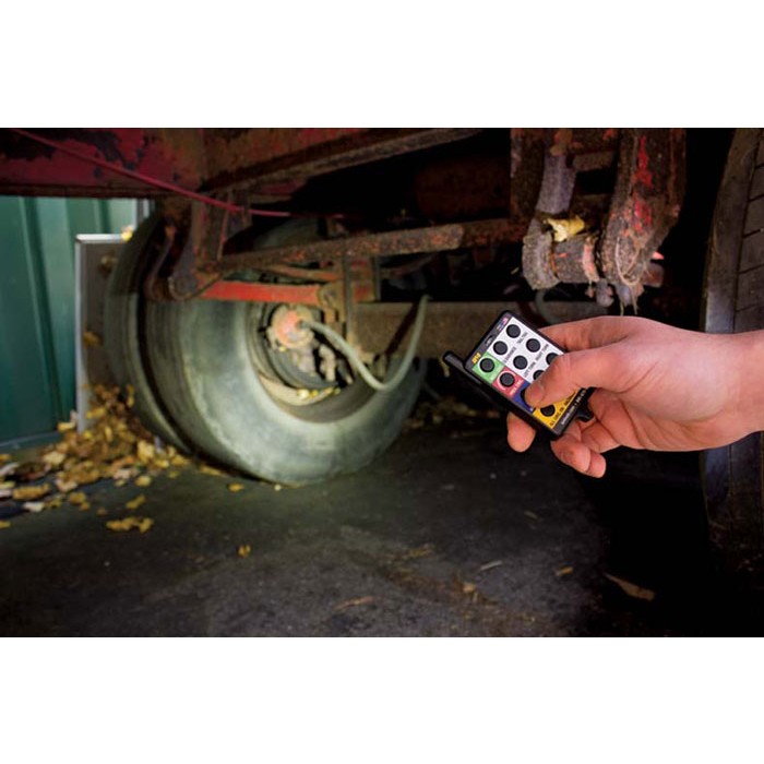 a person is holding a remote control in front of a truck