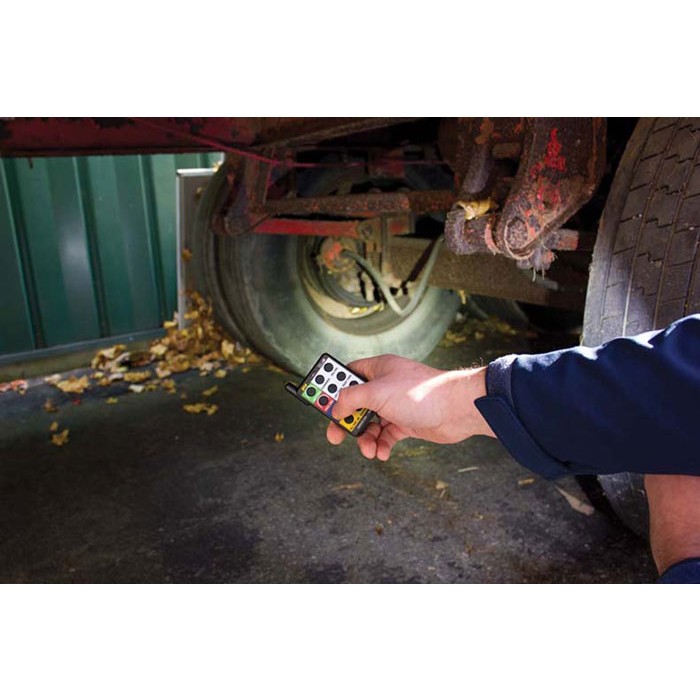 a person is holding a remote control in front of a truck