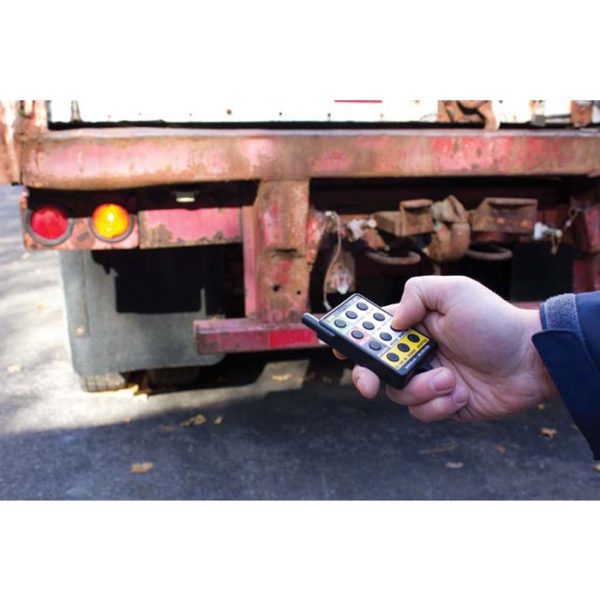 a person is holding a remote control in front of a truck